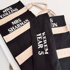 Black and beige tote bags with personalised names on a white background