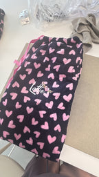 Black and pink heart patterns on pyjama trouser bottoms with 'Lottie' text