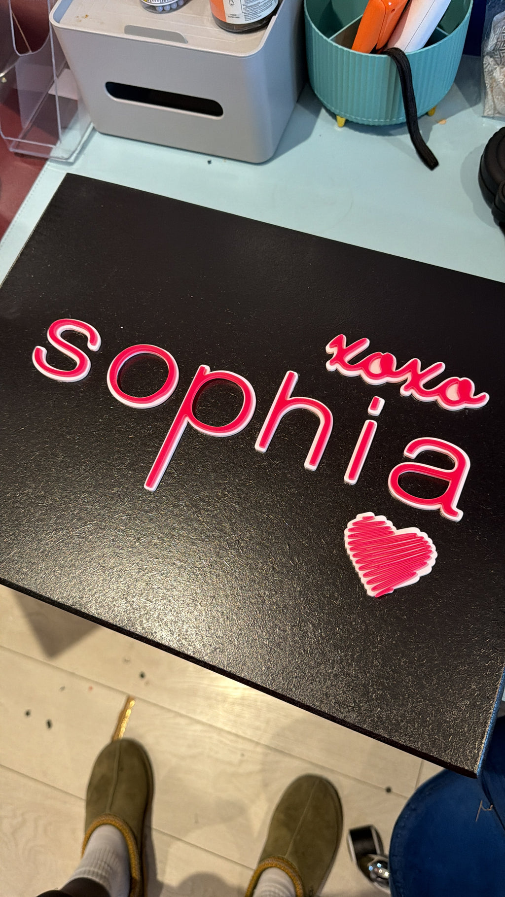 Black board keepsake box with pink 'Sofia' and heart design on a light wooden floor.