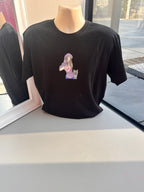 Black event t-shirt with a colourful graphic on a mannequin against a window background