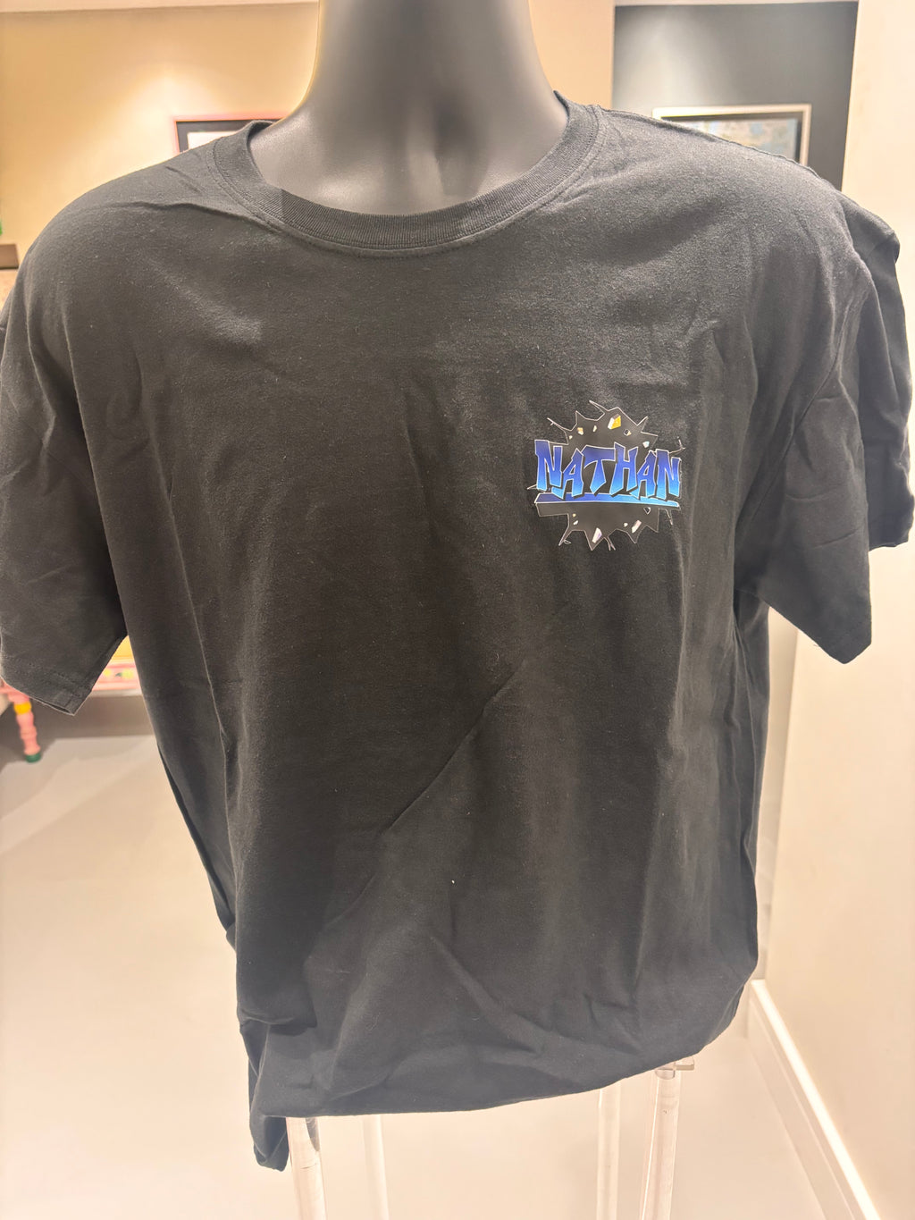 Black event t-shirt with a logo on a mannequin against a neutral background