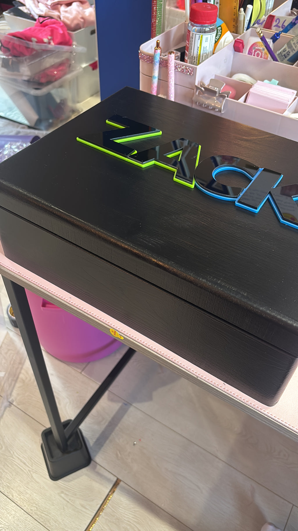 Black keepsake box with green logo on a store shelf