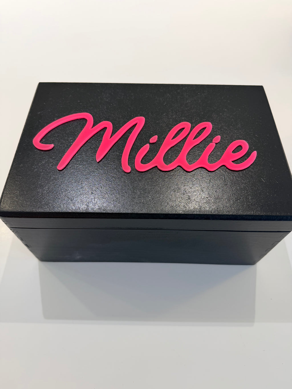 Black keepsake box with pink 'Millie' text on a white background