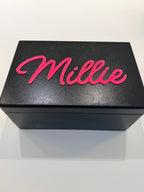 Black keepsake box with pink 'Millie' text on a white background