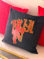 Black logo pillow with red and yellow design on a red cushion