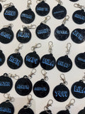 Black round keyrings with blue personalised name text on a white background