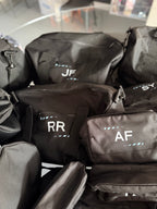 Black sports duffel bag with personalised name initials in white with lined white pattern