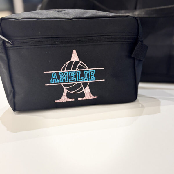 Black washbag with 'AMELIE' branding on a white surface