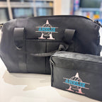 Black washbags with 'AMELIE' branding on a blurred indoor background
