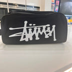 Black boot bag with white logo on a reflective surface