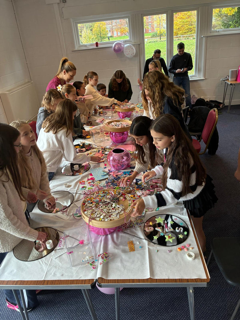 Children engaged in a craft activity around a table in a classroom setting at a Mirrored Memories mirror party