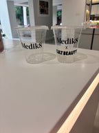 Clear cups for corporate gifting with Medik8 x Cult Beauty branding on a white surface.