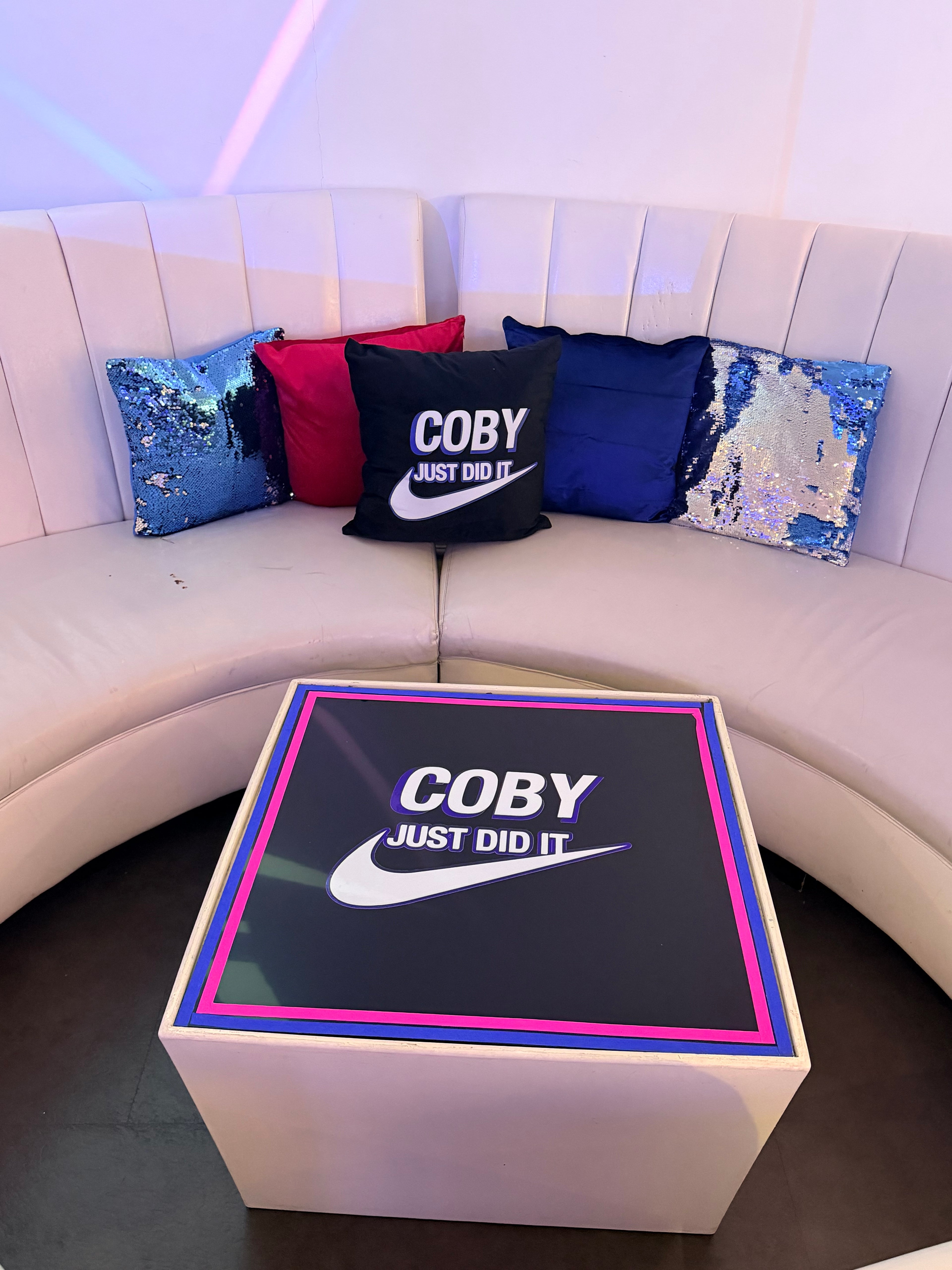 Coby Just Do It box on a white surface with colourful logo pillows in the background