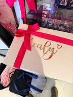 Cream keepsake box with a red ribbon on a cluttered surface