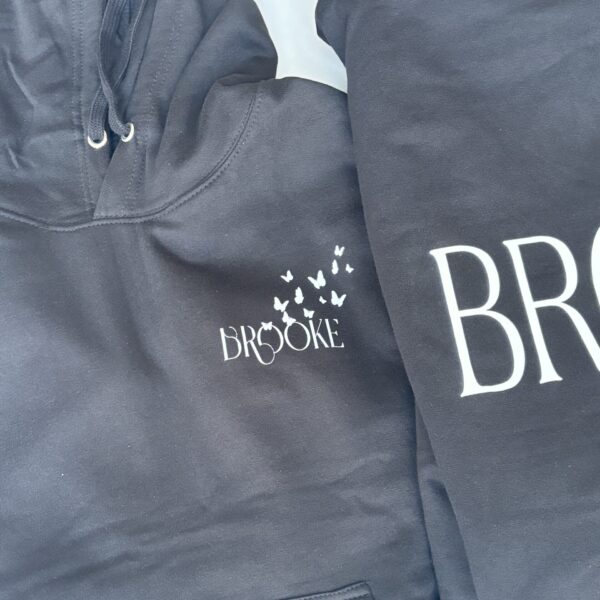 Dark grey hoodie with 'Brooke' branding on a matching sweatshirt.