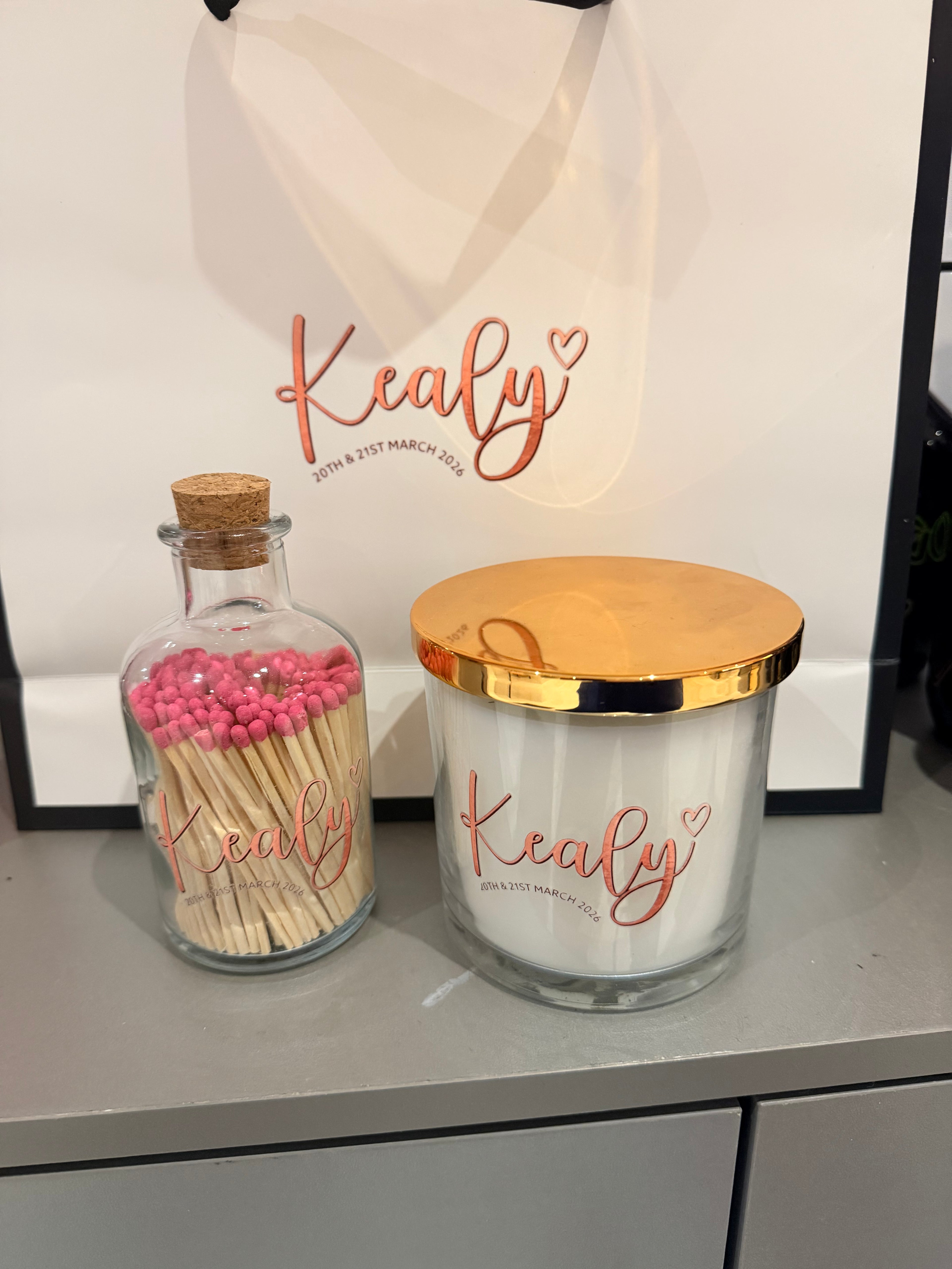 Decorative candle and bottle matches  with matches on a surface, featuring the brand 'Kealy'.