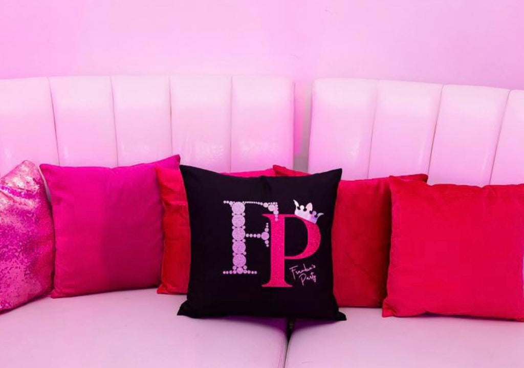 Decorative logo pillows with 'FP' logo on a pink couch