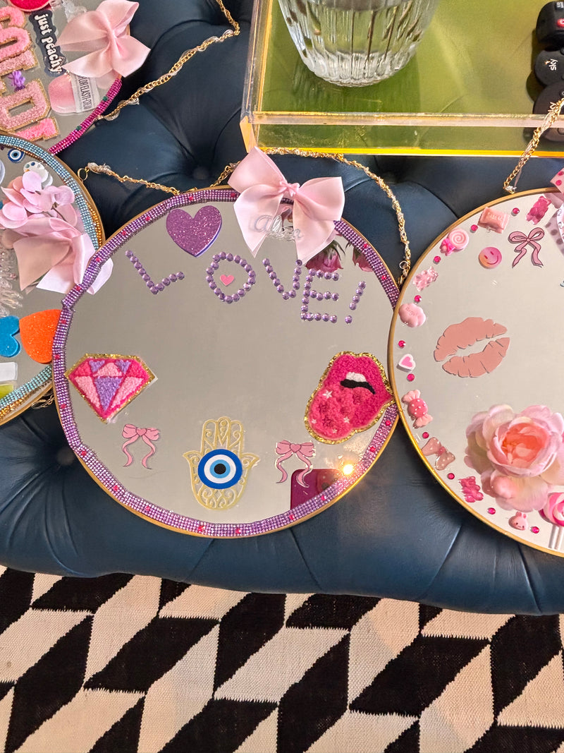 Decorative mirrors with colourful designs on a textured surface taken at a Mirrored Memories mirror party