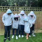Five people wearing personalised grey hoodies in a backyard setting.