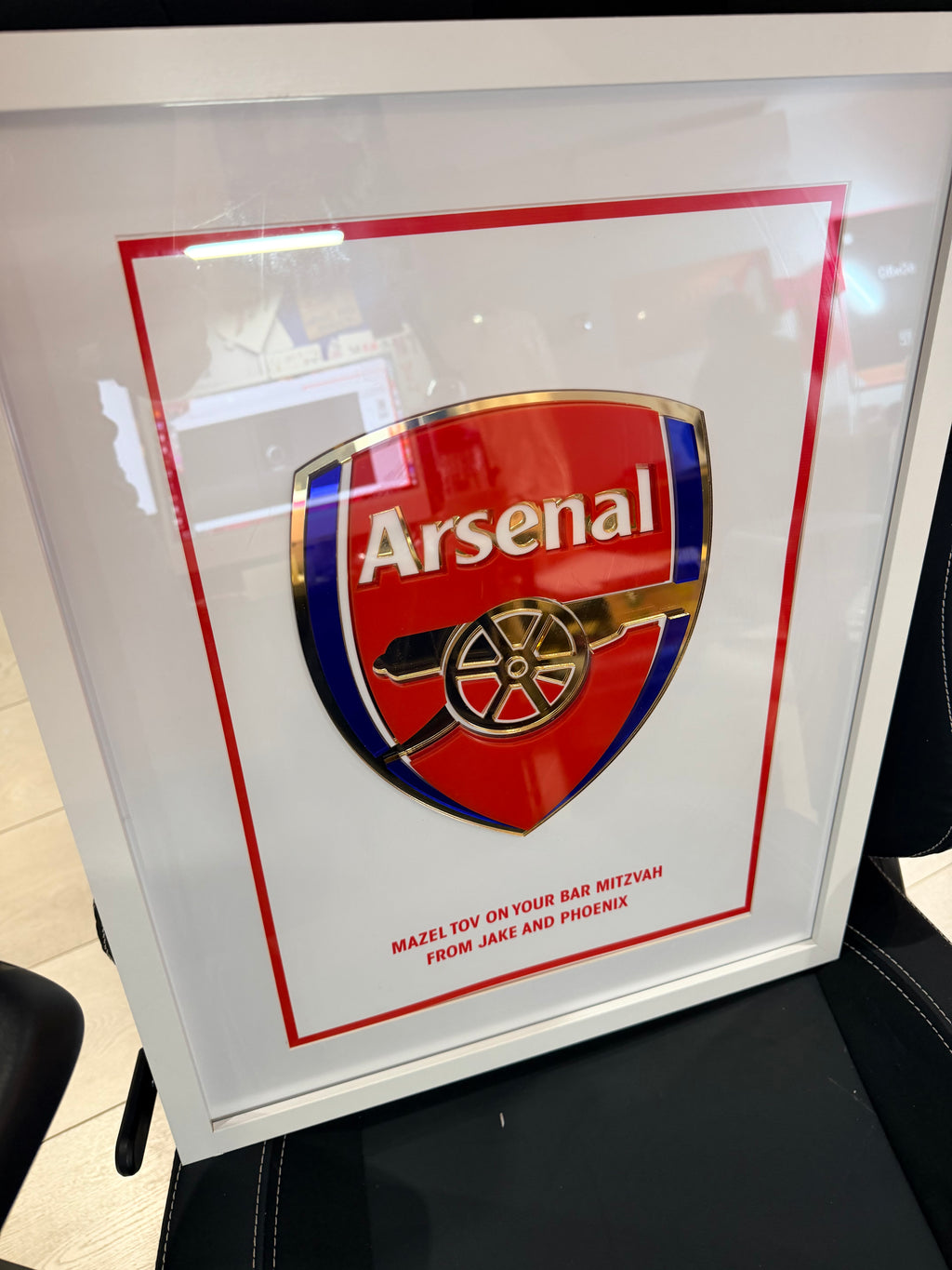 Framed Arsenal logo football gift with a white frame on a white background.