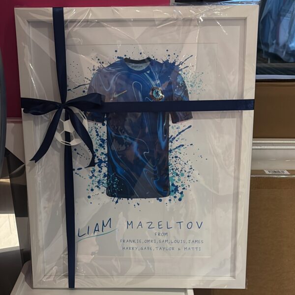 Framed football gift of artwork with a blue shirt design and 'Liam Mazeltov' text, tied with a ribbon.