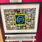 Framed speech gift of photos with a prominent 'Jouie' logo on a pink background and acrylic.