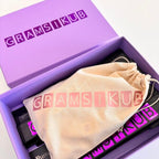 Purple game box with 'GRAMSIKUB' branding and a beige drawstring bag inside.