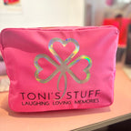 Pink washbag with a four-leaf clover design and 'TONI'S STUFF' text on a blurred background