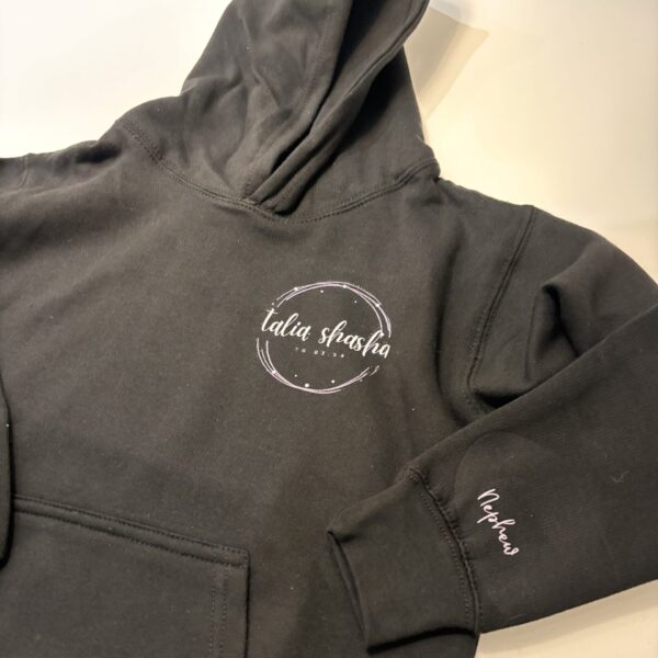 Dark grey hoodie with a logo on the chest and text on the sleeve against a light background