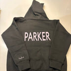 Dark grey hoodie with 'PARKER' printed on the back, laid flat on a light surface.