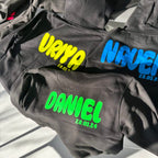 Black hoodies with personalised names and dates on a light background