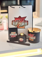 Diffuser with gold accents and a decorative bag featuring a logo and matchbox gift set