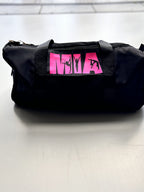 Black washbag with pink logo on a tiled floor
