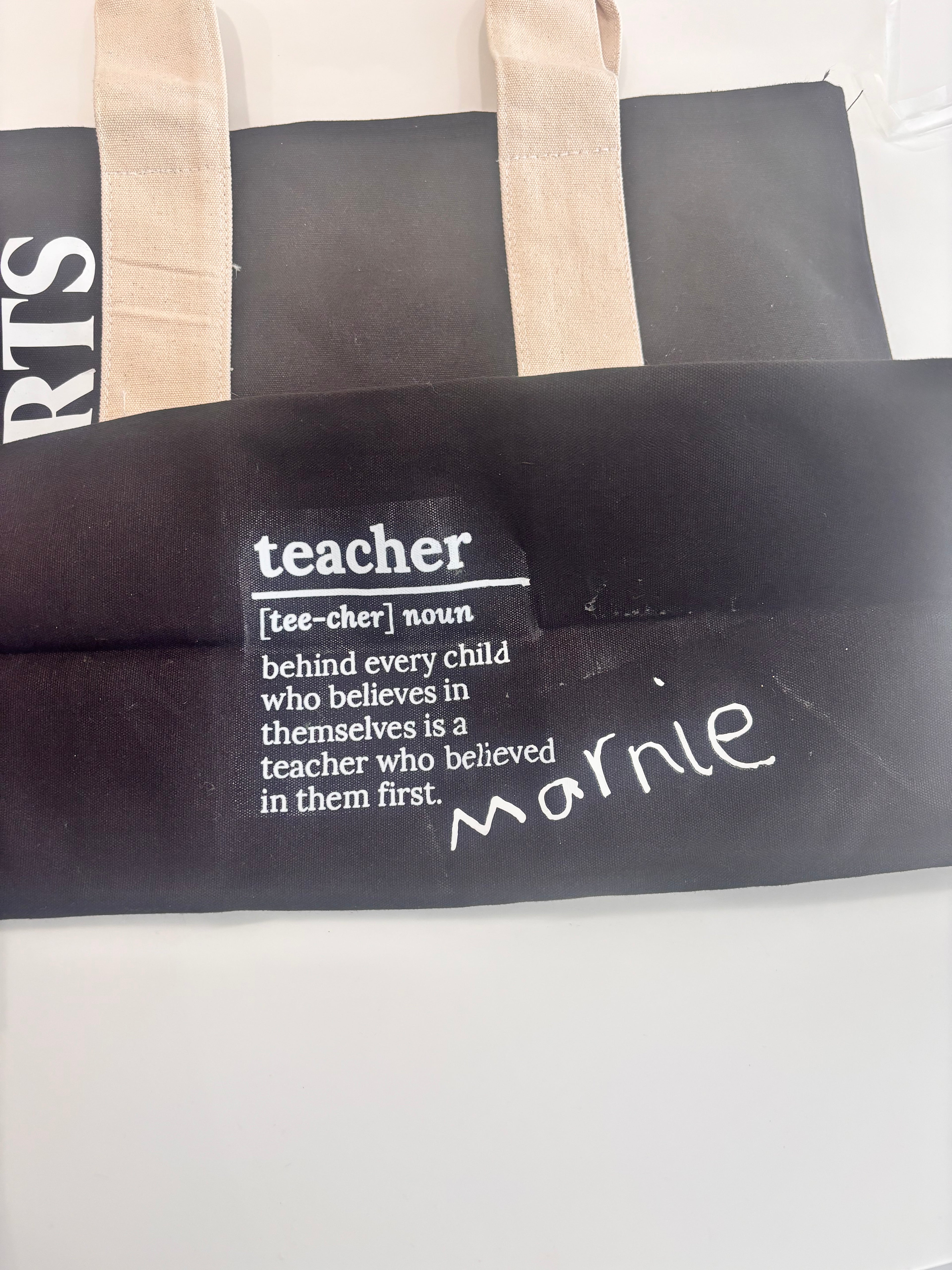 Personalised black tote bag with 'teacher' definition text on a white background