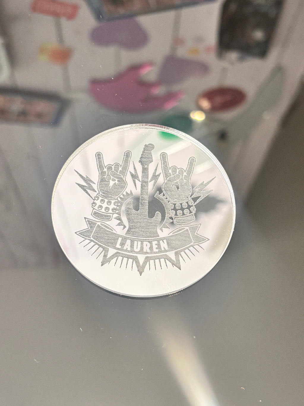 Silver place name with a design on a reflective surface