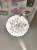 Silver place name with a design on a reflective surface