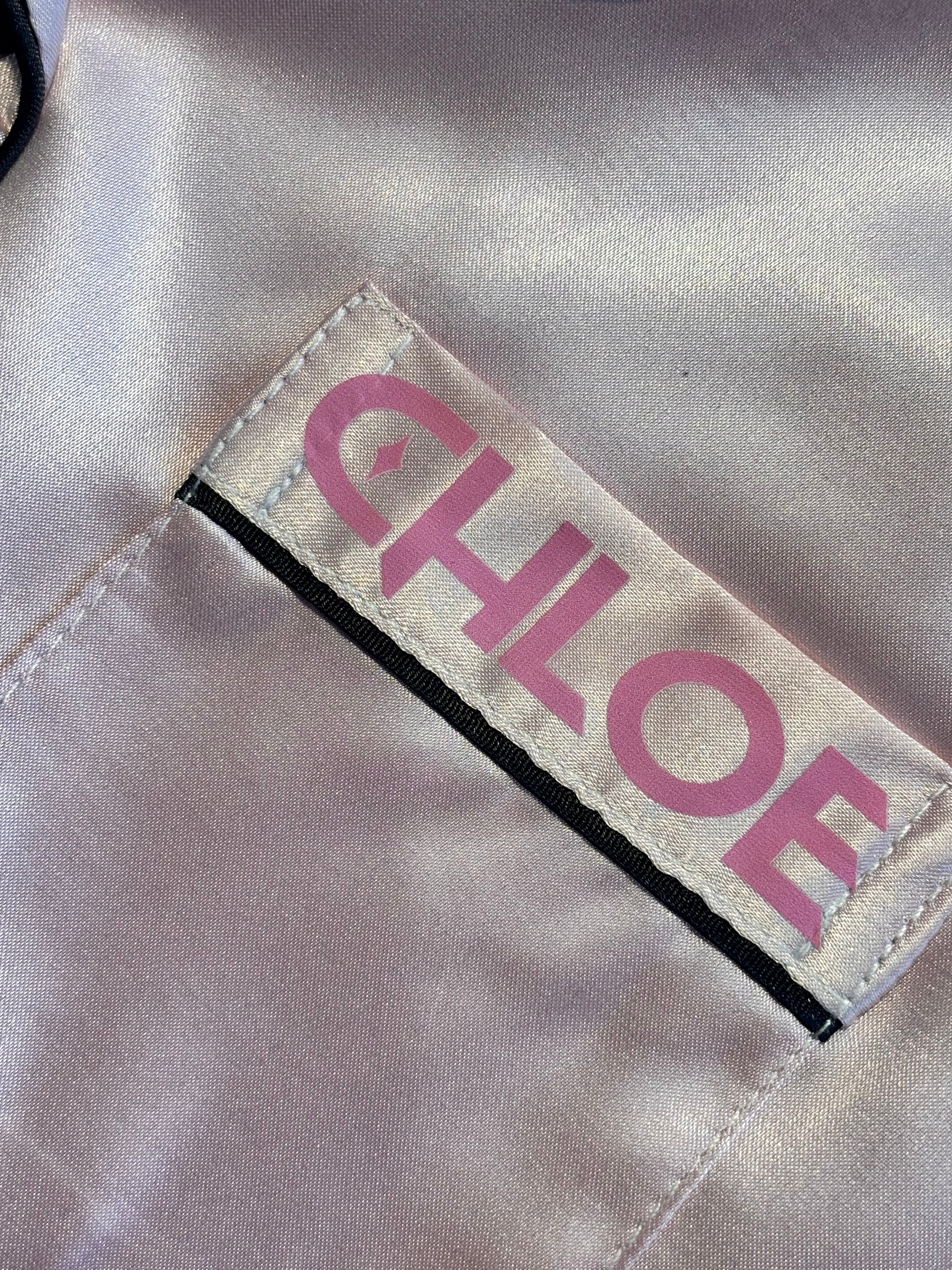 Label with 'CHLOE' printed on a beige pyjama front pocket 