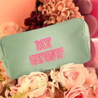 Mint choc chip washbag with 'MY STUFF' text in pink on a floral background