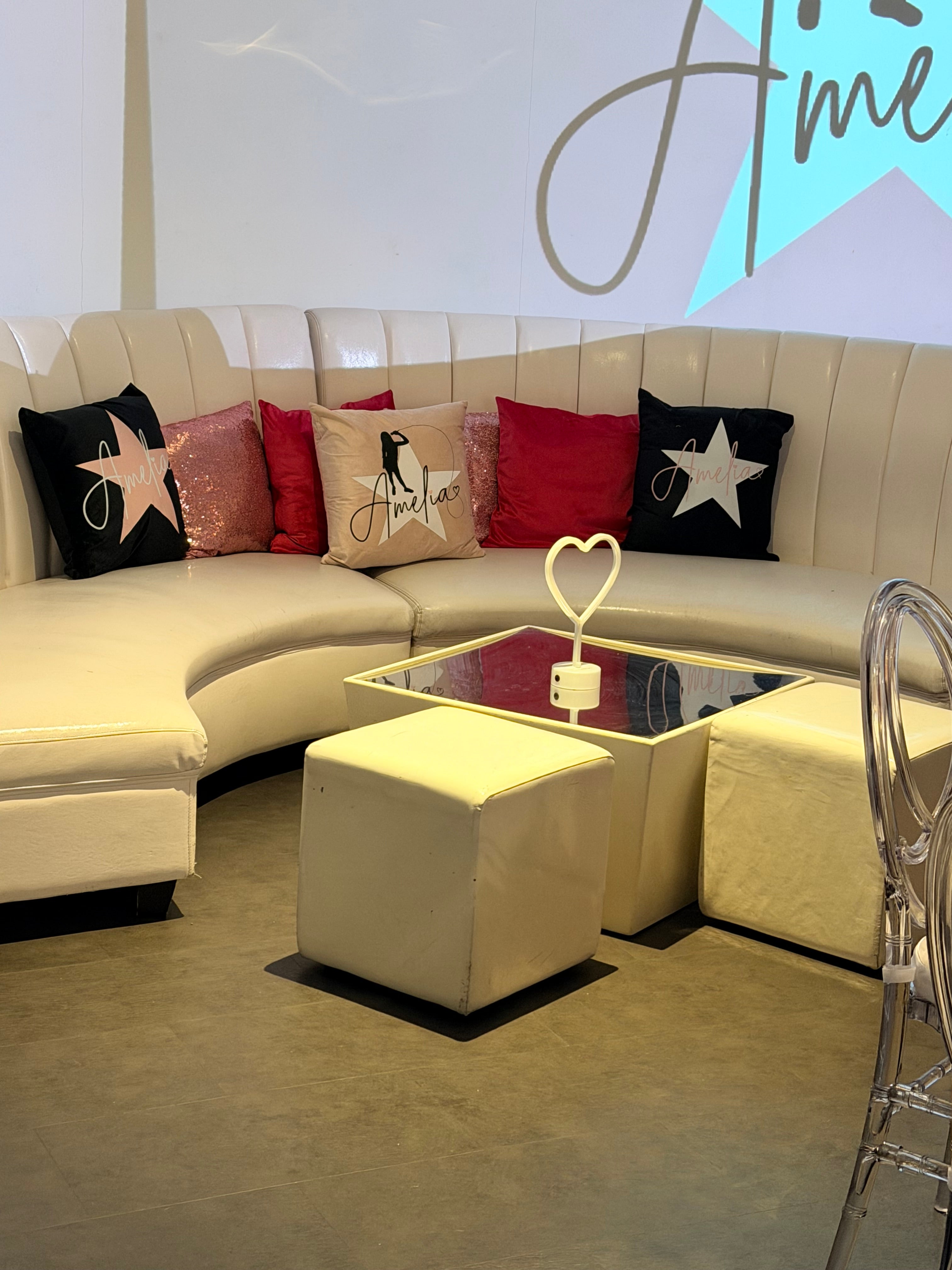Modern living room with a beige sofa, colourful logo pillows and a coffee table.
