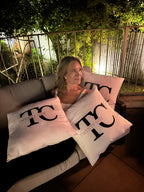 Person lying on outdoor furniture with 'TQ' personalised logo pillows