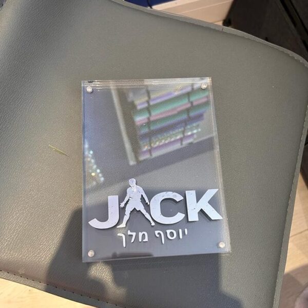 Clear acrylic photo frame with 'JACK' branding on a grey surface