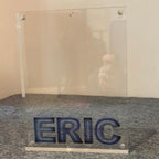 Clear photo frame with 'ERIC' engraved on a textured surface