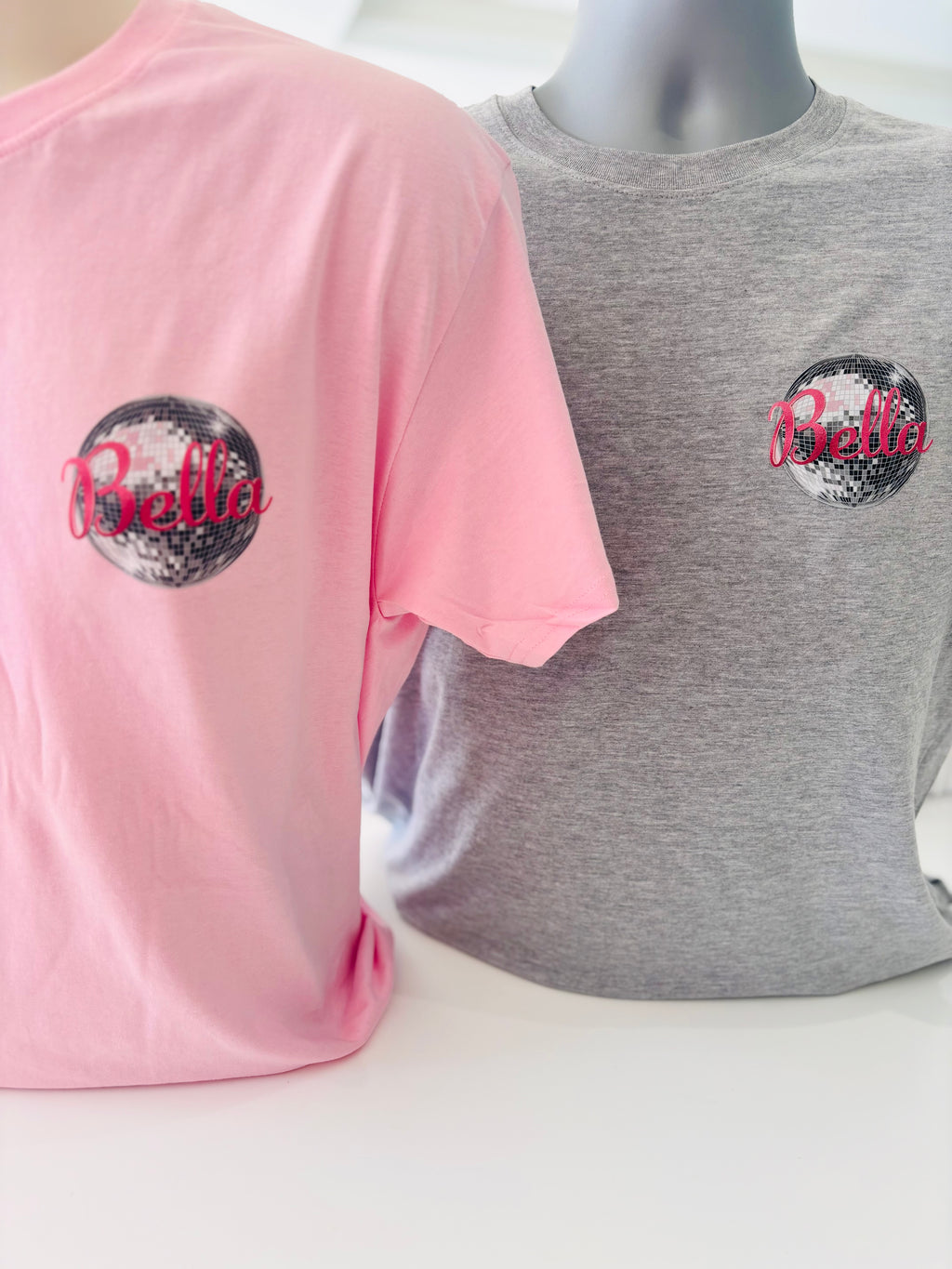 Pink and grey event t-shirts with 'Bella' logo on a white background