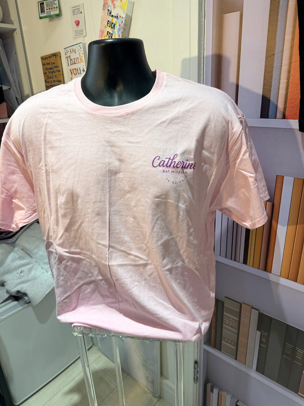 Pink event t-shirt with 'Calvin Klein' branding on a mannequin in a store setting.
