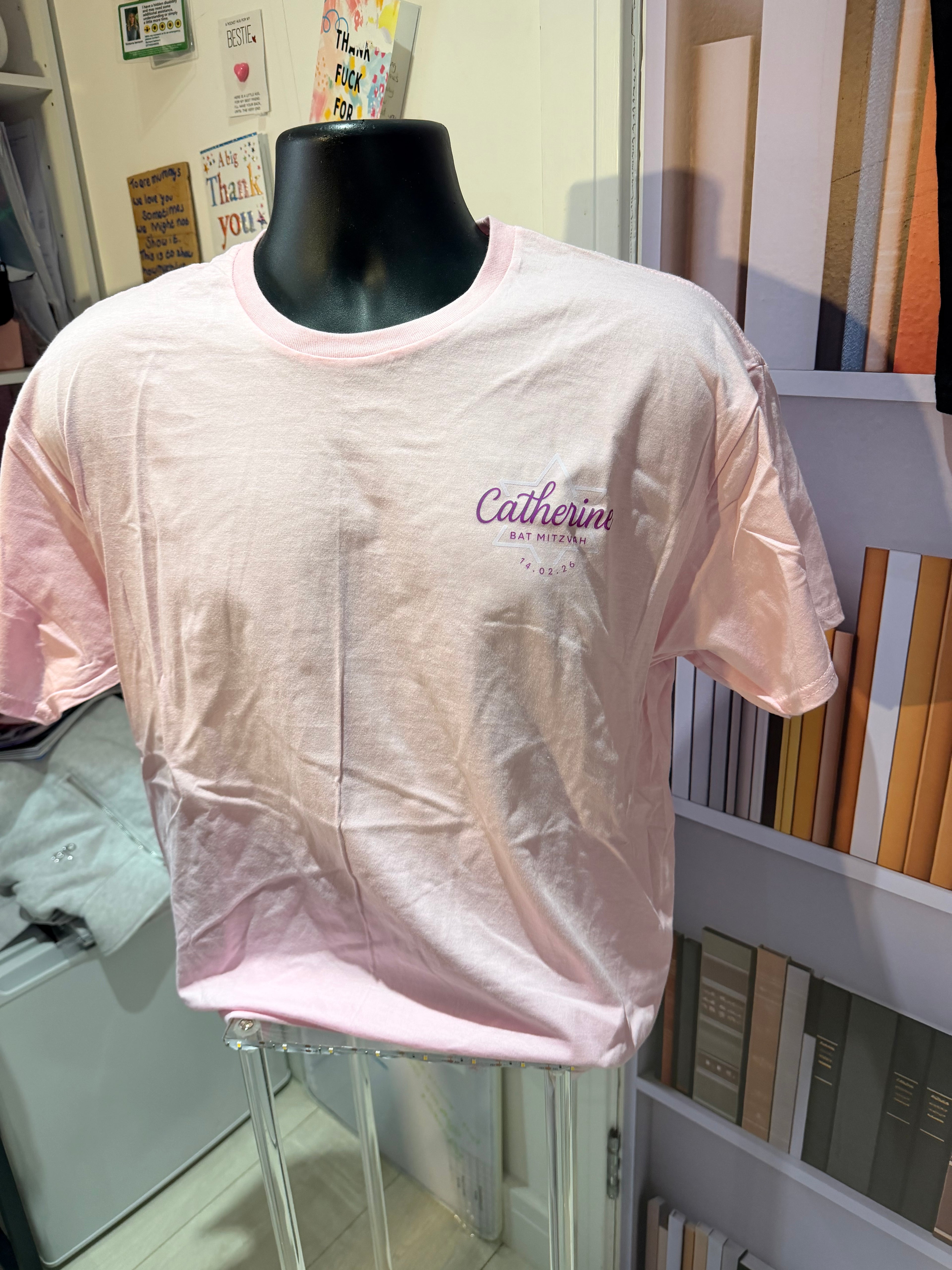 Pink event t-shirt with 'Calvin Klein' branding on a mannequin in a store setting.