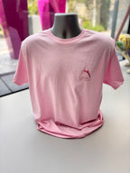 Pink event t-shirt with a logo on a mannequin against a blurred outdoor background