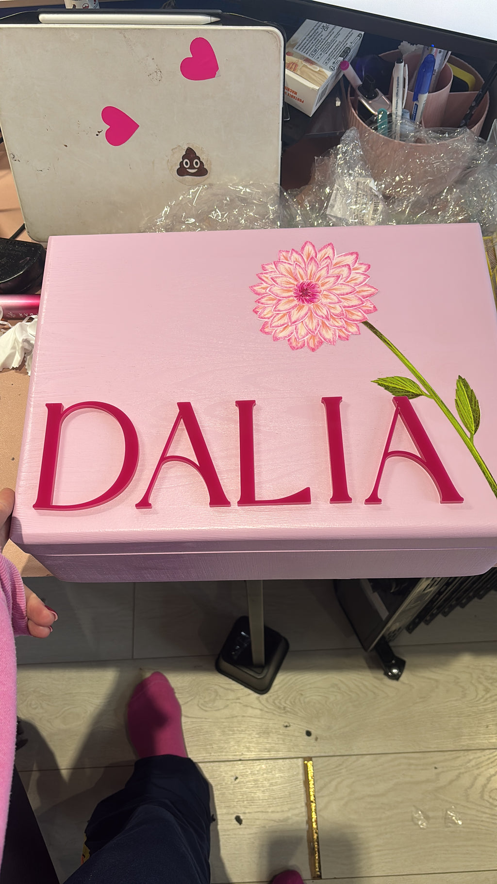 Pink keepsake box with 'DALIA' branding on a cluttered surface
