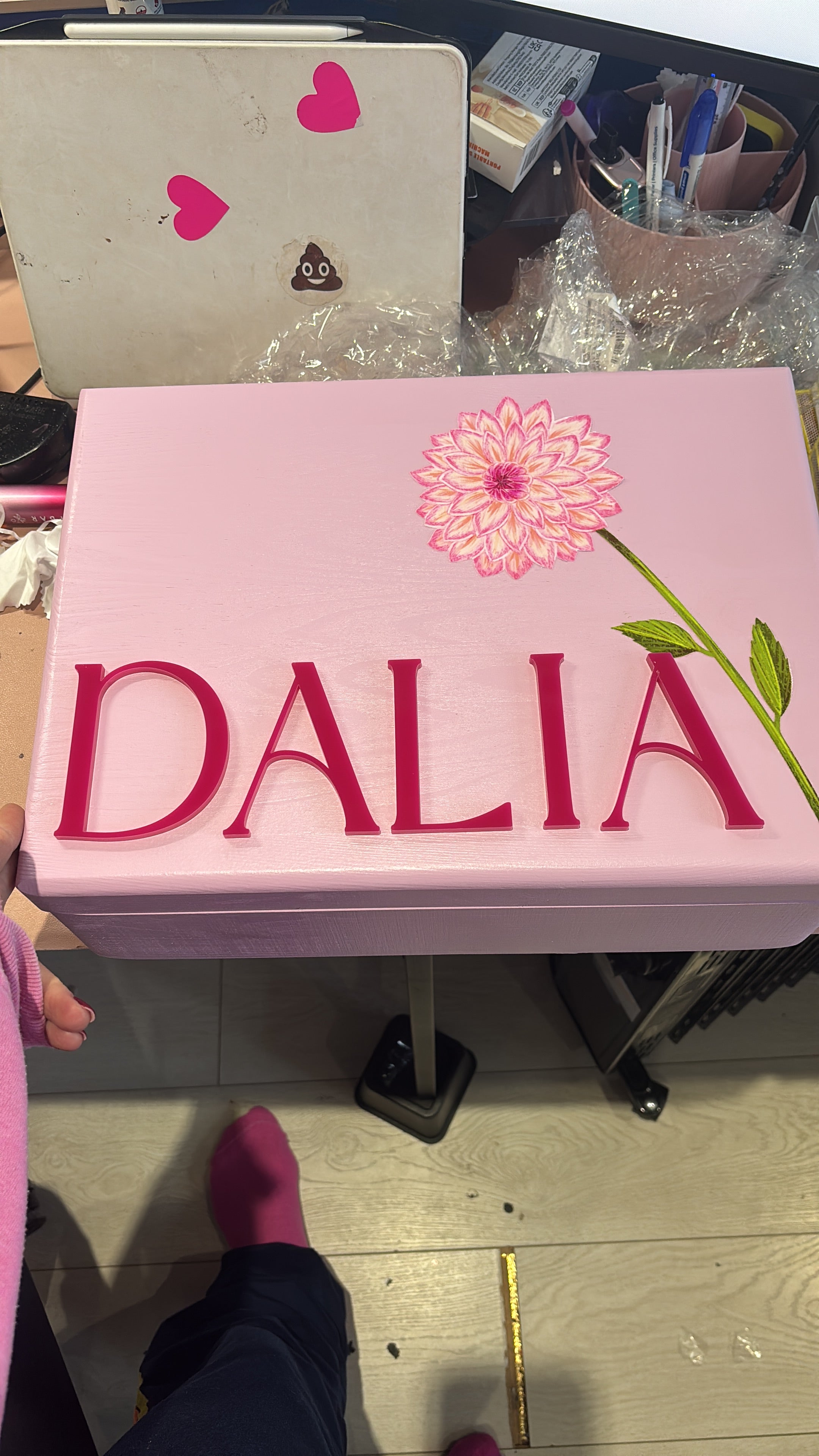 Pink keepsake box with 'DALIA' branding on a cluttered surface