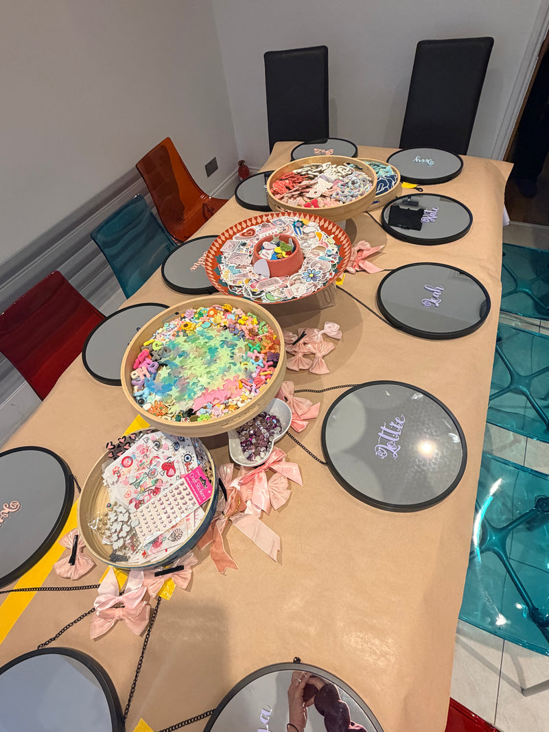 Round tables with decorative mirrors  and chairs around them in a room taken at a Mirrored Memories mirror party