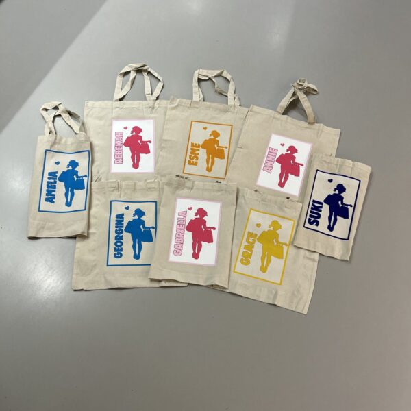 Set of tote bags with printed designs on a grey surface